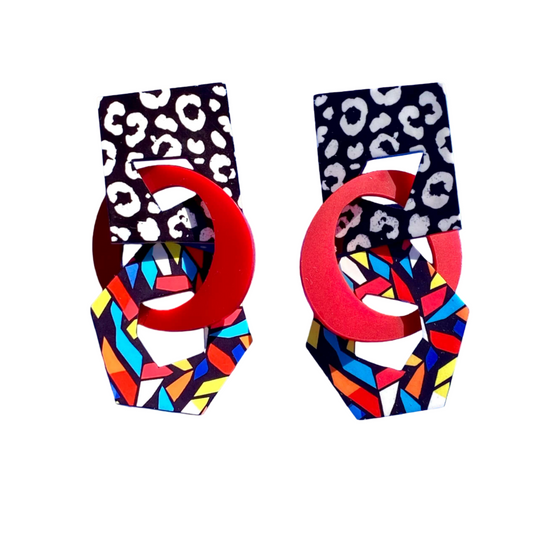 Pair of colorful geometric-patterned earrings with red centers.