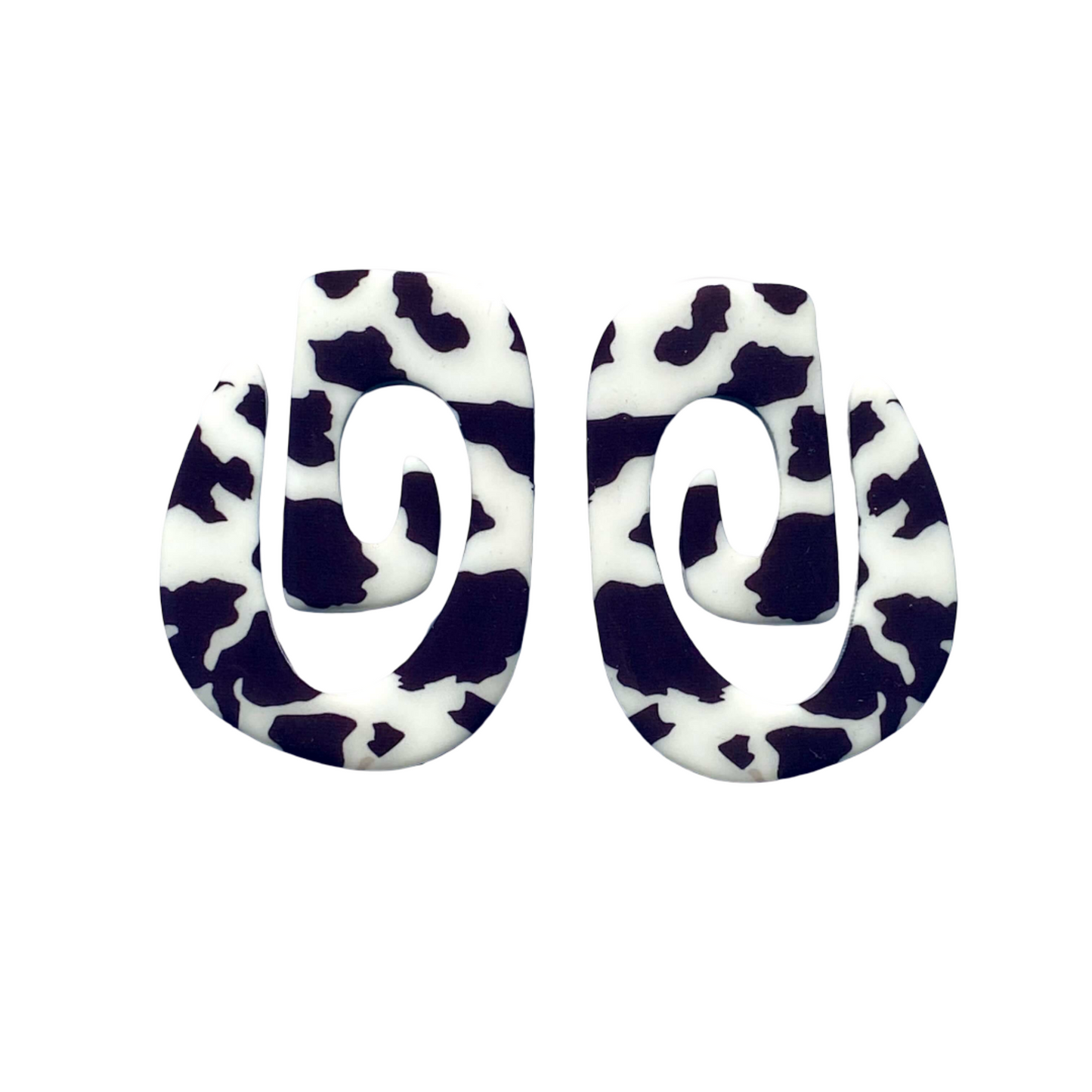 Pair of earrings with black and white cow print design.
